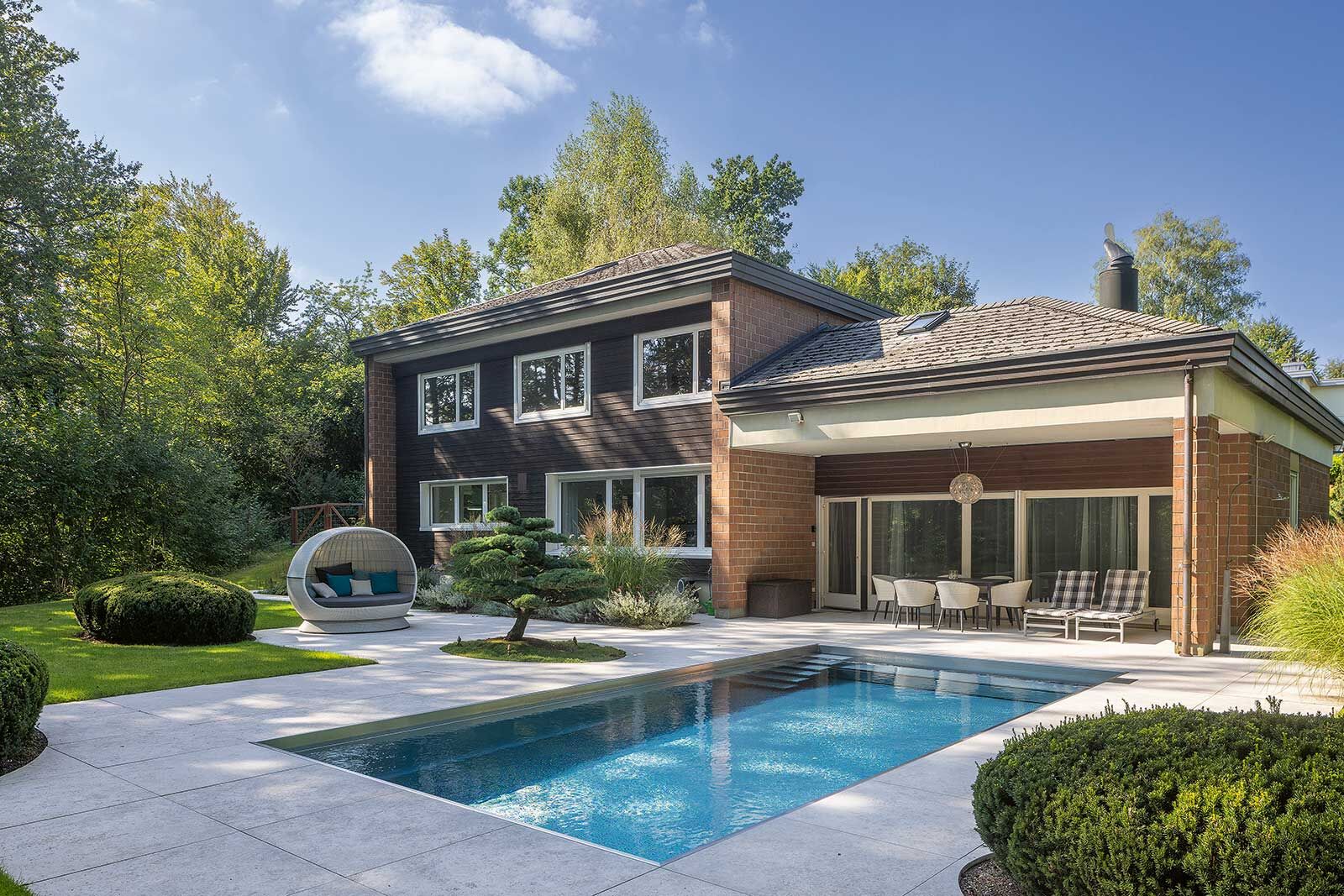 Der neue Garten mit Pool verbindet gekonnt Landhauscharme mit moderner Eleganz.