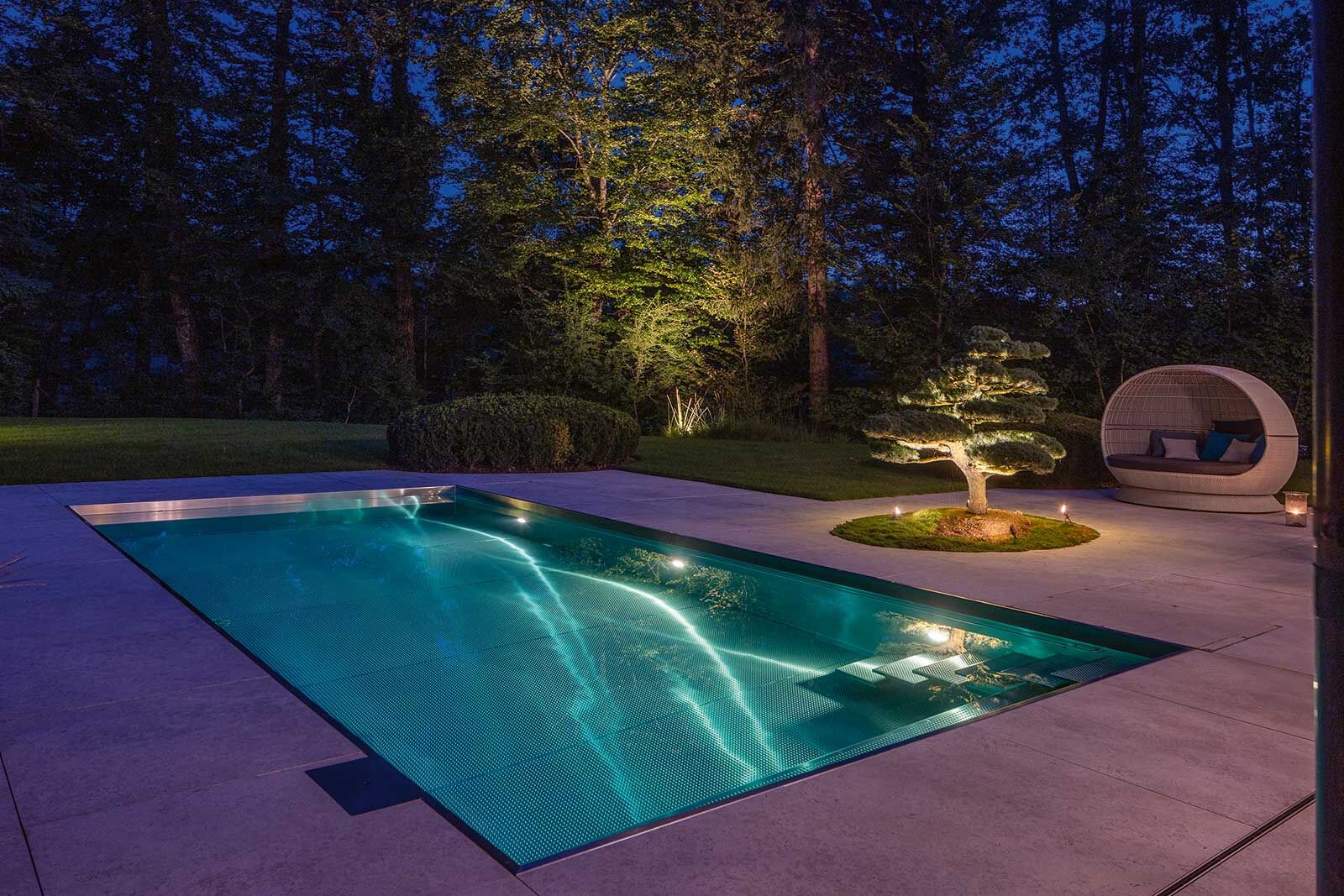 Bei Nacht verwandelt sich der Pool mit seinem faszinierenden Lichtspiel in eine magische Kulisse.