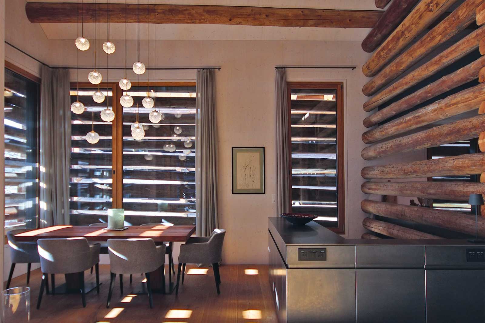 Das Sideboard in Schwarzstahl ist zugleich der Absturzschutz für die Treppe in die untere Etage. Die Ecke mit den zwei Fenstern ist der Essbereich. Abends wird er von der Deckenlampe erhellt, die die Bauherrin auf der Mailänder Möbelmesse gesehen hatte.