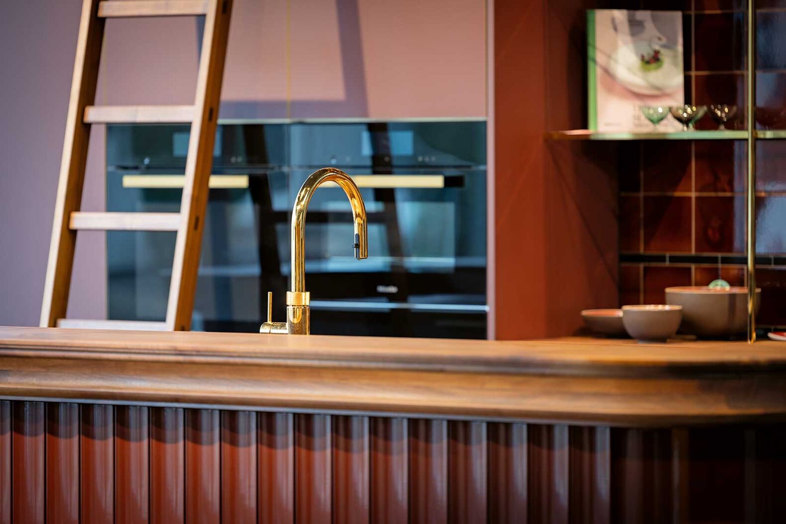 Retro in Nussbaum: Auf 400 Quadratmetern entdecken Besucher im Showroom der Späti Innenausbau AG verschiedene Küchenwelten, ein stimmungsvolles Bad, massgefertigte Tische und weitere Möbel. Diese Küche mit Bar ist ein Ort, an dem Menschen zusammenkommen, Gespräche entstehen und Genuss zelebriert wird. Im Zentrum steht eine Kücheninsel mit grosszügiger Arbeitsplatte aus massivem europäischem Nussbaum. Das edle Holz verleiht der Küche Wärme, Tiefe und eine natürliche Ausstrahlung, die sofort zum Verweilen einlädt. Späti Innenausbau AG, www.spaeti-innenausbau.ch