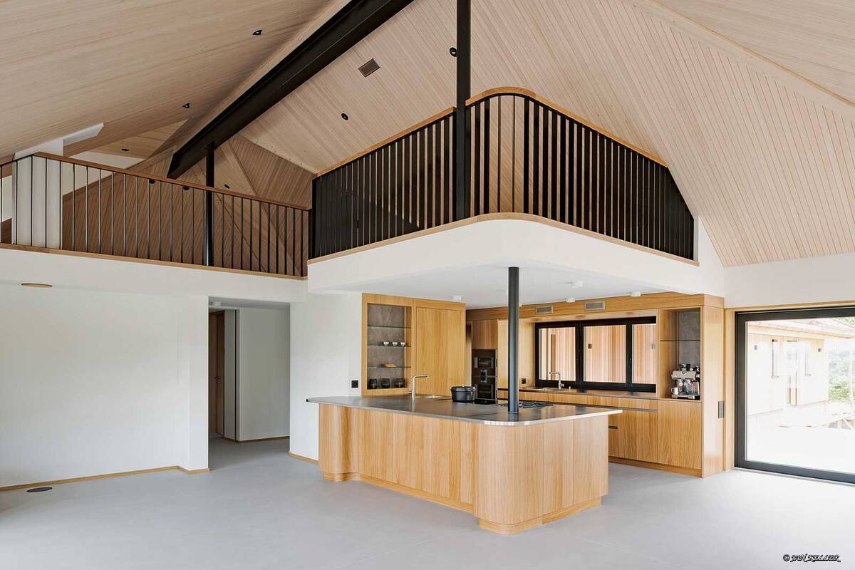 Die Küche heisst «Eichenpoesie» und zeigt, wie geschwungene Formen mit dem regionalen Holz zusammen harmonieren. Die besondere Ästhetik kommt von dem durchdachten Layout und dem Kontrast zum Edelstahl. Schreinerei Fehlmann AG.