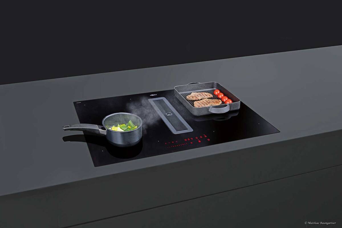 Der «Airstream 7852» in der Optik «Essential Mattglas SaphirMatt» ist geräuscharm und einfach zu reinigen durch das ausziehbare Schubfach. Das Kochfeld-Abzugs-System passt sich durch die Chefkochfunktion mit Topferkennung und Ankochautomatik an die Situation an und schützt vor Überkochen. Erge GmbH.