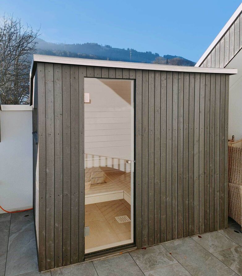 Wer eine Outdoor-Sauna will, braucht nicht unbedingt einen Garten. Auf dieser Terrasse wurde die Aussenverkleidung der Sauna mit ihren Lamellen an die Holzfassade angepasst, um ein einheitliches Bild zu bekommen. Ging Saunabau AG, www.saunabau.ch